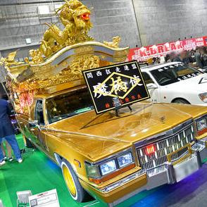 てっぺんには黄金の龍！　ピンクの電飾にタケヤリもヤバイ！　パンチ強すぎな霊柩車の中身とは？　【大阪オートメッセ2024】