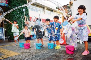 打ち水で涼を演出　入間市駅前で子どもたちが柄杓で水まき　「毎日暑い。打つ水は楽しくて涼しくなった」と笑顔