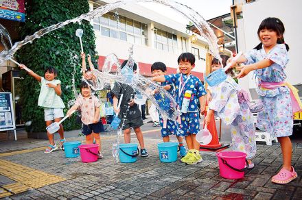 打ち水で涼を演出　入間市駅前で子どもたちが柄杓で水まき　「毎日暑い。打つ水は楽しくて涼しくなった」と笑顔