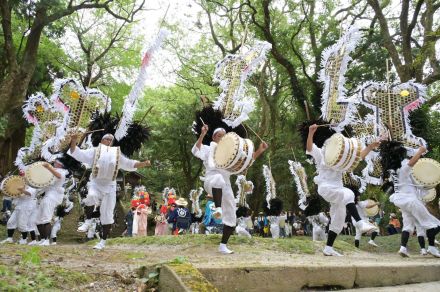 緑が包む境内で、白装束はかねや太鼓を打ち鳴らし、矢旗揺らして勇ましく舞う　県無形民俗文化財・伊作太鼓踊りを奉納　日置市・南方神社